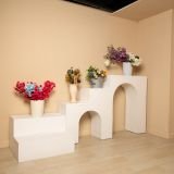 Escalera blanca con arcos y flores para exhibición de productos en estudio fotográfico estilo Santorini Bogotá.